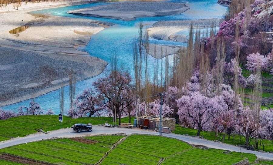 Spring blossom orchards in Mehdiabad Village alongside the winding Indus River valley in Kharmang District, Gilgit-Baltistan, Pakistan.