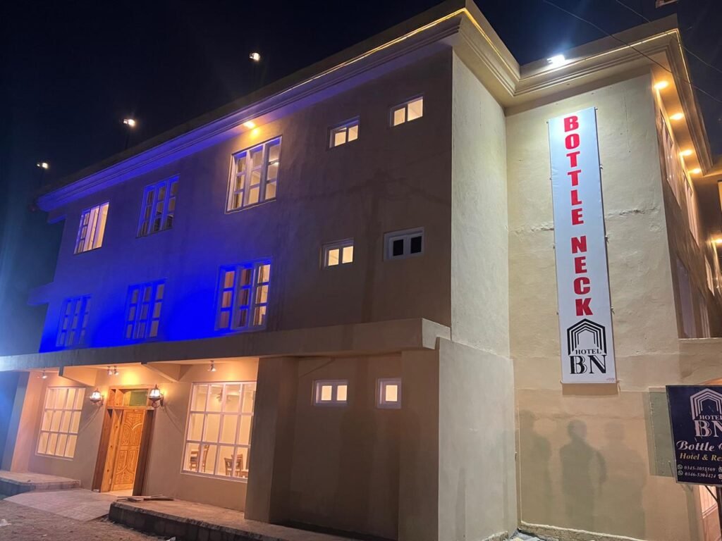 Illuminated facade of Hotel Bottle Neck at night in Skardu, Gilgit-Baltistan.
