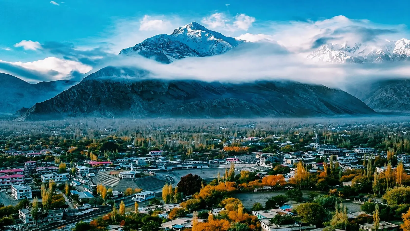Panoramic scenic view of majestic snow-capped Karakoram mountains and turquoise waters in Skardu Valley, a premier travel destination by Northern Discover.
